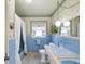 Vintage bathroom featuring blue tile, unique fixtures, and a charming window with curtains at 6823 Oak Hill Dr, New Port Richey, FL 34653