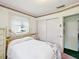 A bright bedroom featuring a queen bed, a sliding door closet, and a window letting in natural light at 6823 Oak Hill Dr, New Port Richey, FL 34653