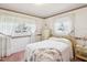 Bright bedroom with a queen-sized bed, sheer curtains, and light-colored furniture showcasing a cozy and peaceful space at 6823 Oak Hill Dr, New Port Richey, FL 34653