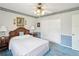 Well-lit bedroom with a queen bed, blue carpet, striped wallpaper, and classic light fixture for a vintage aesthetic at 6823 Oak Hill Dr, New Port Richey, FL 34653