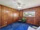 Charming bedroom with natural wood paneling, comfortable armchair, and ample natural light at 6823 Oak Hill Dr, New Port Richey, FL 34653