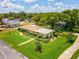 Aerial view of well-kept single-story home with large yard and mature landscaping and verdant lawn at 6823 Oak Hill Dr, New Port Richey, FL 34653