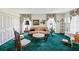 Cozy living room features vintage décor, including floral curtains and a plush green carpet at 6823 Oak Hill Dr, New Port Richey, FL 34653