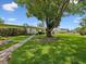 Grassy lawn with mature tree provides ample shade to this charming home and yard at 6823 Oak Hill Dr, New Port Richey, FL 34653