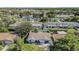 An aerial view showcases this charming single-story house surrounded by mature trees in a well-established neighborhood at 6989 300 Th N Ave, Clearwater, FL 33761