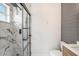 Modern bathroom featuring a marble tiled shower with a glass door and wood paneling at 6989 300 Th N Ave, Clearwater, FL 33761