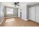Bright bedroom with hardwood floors, a ceiling fan, a closet, and a view into the ensuite bathroom at 6989 300 Th N Ave, Clearwater, FL 33761
