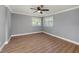 Spacious bedroom featuring wood floors, ceiling fan, and natural light from two windows at 6989 300 Th N Ave, Clearwater, FL 33761