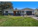 Charming single-story home with a well-maintained lawn, neutral colors, and an attached garage in a sunny setting at 6989 300 Th N Ave, Clearwater, FL 33761