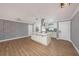 Spacious open layout showcasing modern kitchen island and adjacent living area with beautiful floors and custom shelving at 6989 300 Th N Ave, Clearwater, FL 33761