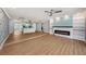 Spacious open-concept living room featuring wood floors, a fireplace, and seamless flow into the modern kitchen at 6989 300 Th N Ave, Clearwater, FL 33761