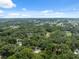 Wide aerial view showing homes in a densely wooded region under a blue sky at 7340 20Th, Zephyrhills, FL 33540