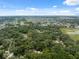 Broad aerial shot highlighting a verdant, tree-filled landscape and scattered houses at 7340 20Th, Zephyrhills, FL 33540