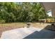 The spacious backyard is enclosed by a chain-link fence and features a concrete patio area and mature trees at 7340 20Th, Zephyrhills, FL 33540