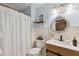 Charming bathroom with vanity, decorative mirror, and shower with curtain at 7340 20Th, Zephyrhills, FL 33540