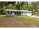 Charming single-story home with gray siding, screened-in porch, attached garage and mature landscaping at 7340 20Th, Zephyrhills, FL 33540