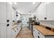 Bright kitchen features white cabinets, stainless steel appliances, and wood-look flooring at 7340 20Th, Zephyrhills, FL 33540
