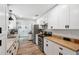 Bright kitchen features white cabinets, stainless steel appliances, and wood-look flooring at 7340 20Th, Zephyrhills, FL 33540
