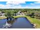 Scenic aerial shot of a community pond with a fountain, surrounded by lush trees and well-kept lawns at 7736 Chadwick Dr, New Port Richey, FL 34654