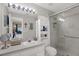 Bathroom with a white vanity, large mirror, and glass-enclosed shower for a clean, modern look at 7736 Chadwick Dr, New Port Richey, FL 34654