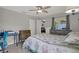 Bedroom featuring a floral-patterned bed, desk, dresser, ceiling fan, and access to outdoor patio at 7736 Chadwick Dr, New Port Richey, FL 34654