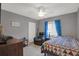 Bedroom with a ceiling fan, an armchair, a window with curtains, and a bed with geometric patterned comforter at 7736 Chadwick Dr, New Port Richey, FL 34654