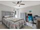 Bedroom with a floral-patterned bed, ceiling fan, dresser and desk perfect for a study area at 7736 Chadwick Dr, New Port Richey, FL 34654