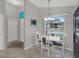 Bright dining area with white table, chairs, and a view of the front yard through a large window at 7736 Chadwick Dr, New Port Richey, FL 34654