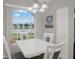 Dining area featuring a bright view of the lake, a white table and matching chairs at 7736 Chadwick Dr, New Port Richey, FL 34654