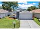 Well-maintained home with fresh landscaping, an American flag, and a two-car garage at 7736 Chadwick Dr, New Port Richey, FL 34654