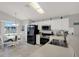 Bright kitchen with white cabinetry, black appliances, tile floors, and an adjacent dining area at 7736 Chadwick Dr, New Port Richey, FL 34654