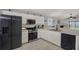 Modern kitchen featuring white cabinetry, stainless steel appliances, and an open layout with tile floors at 7736 Chadwick Dr, New Port Richey, FL 34654