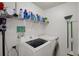Bright laundry room featuring updated appliances, shelving for supplies, and a convenient vacuum storage area at 7736 Chadwick Dr, New Port Richey, FL 34654
