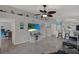 Open living room with ceiling fan, tile floor and a television with a beach landscape at 7736 Chadwick Dr, New Port Richey, FL 34654