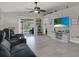 Open-concept living room with tile floors, ceiling fan, and sliding glass doors to the backyard at 7736 Chadwick Dr, New Port Richey, FL 34654