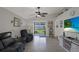 Open living room with high ceiling, ceiling fan, sliding glass doors, tile floor, and television at 7736 Chadwick Dr, New Port Richey, FL 34654