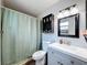 Bright bathroom with modern vanity, tiled walls, and a shower with a decorative curtain at 7979 Avenal Loop, New Port Richey, FL 34655