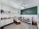 Charming Bedroom featuring a crib, dresser, and a green accent wall at 7979 Avenal Loop, New Port Richey, FL 34655