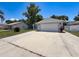 Charming single-story home with an attached two-car garage and concrete driveway at 7979 Avenal Loop, New Port Richey, FL 34655