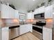 Well-lit kitchen with stainless steel appliances, granite countertops, and white cabinetry at 7979 Avenal Loop, New Port Richey, FL 34655