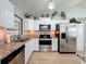 Updated kitchen featuring granite countertops, stainless steel appliances, and ample cabinet space at 7979 Avenal Loop, New Port Richey, FL 34655
