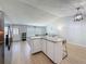 Open-concept living area featuring an island with granite countertop and light hardwood flooring at 7979 Avenal Loop, New Port Richey, FL 34655