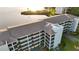 Aerial view of condo building featuring lush landscaping and covered parking at 8211 Brent St # 836, Port Richey, FL 34668
