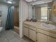 Bathroom with a large mirror over a vanity with built-in storage and a shower/bath with blue curtain at 8211 Brent St # 836, Port Richey, FL 34668