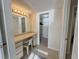 Bathroom vanity area with ample lighting, a large mirror, built in storage and closet nearby at 8211 Brent St # 836, Port Richey, FL 34668