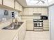 Well-lit kitchen featuring stainless steel appliances, a pass-through window and tiled flooring at 8211 Brent St # 836, Port Richey, FL 34668