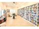 Large, sunlit library with extensive bookshelves, comfortable seating, and a desk at 8211 Brent St # 836, Port Richey, FL 34668