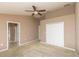 Spacious primary bedroom with ceiling fan, carpet flooring, and large closet space at 8409 Blue Rock Dr, New Port Richey, FL 34653