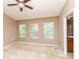 Carpeted bedroom with three large windows for natural light and access to an ensuite bathroom at 8409 Blue Rock Dr, New Port Richey, FL 34653
