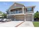 Three-story townhome featuring a private balcony, attached garages, and neutral exterior paint at 8409 Blue Rock Dr, New Port Richey, FL 34653